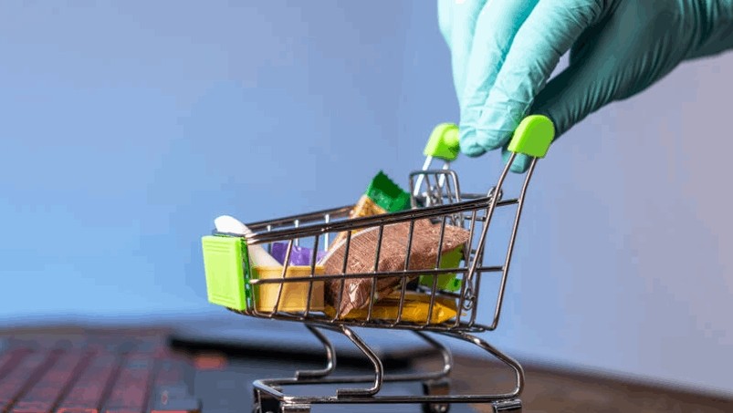 A small cart with products in it moved by a hand 